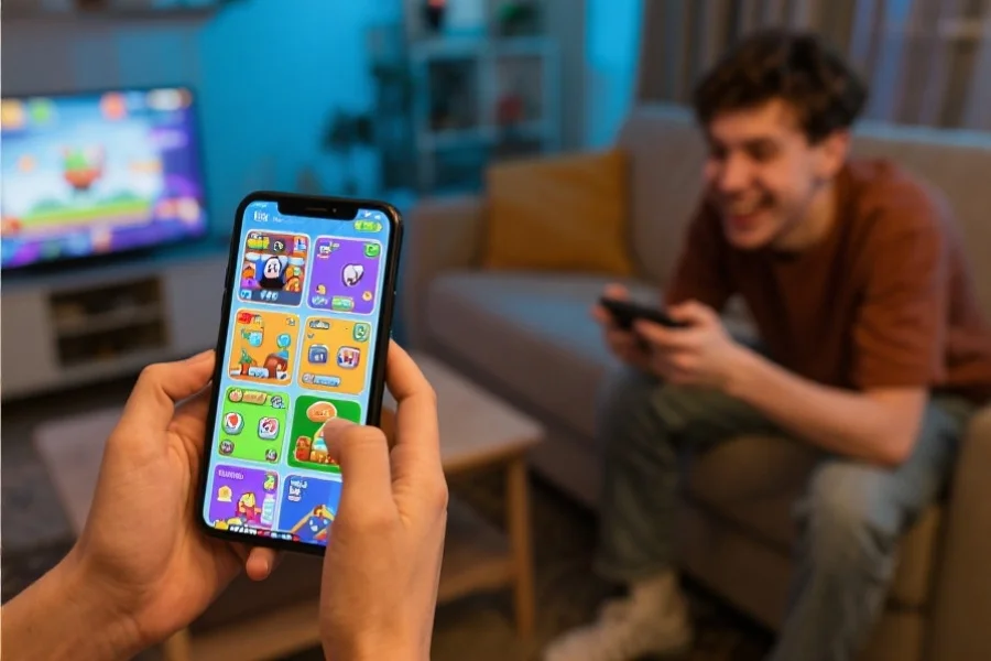 年轻玩家在家里愉快地使用智能手机，屏幕上显示各种休闲娱乐游戏界面，氛围轻松愉快